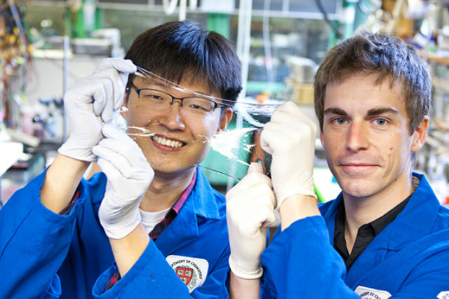 Ведущие авторы разработки Цзеон-Юнь Сунь и Кристофер Кеплингер держат в руках гибкий прозрачный дисплей (фото Eliza Grinnell/SEAS Communications). 