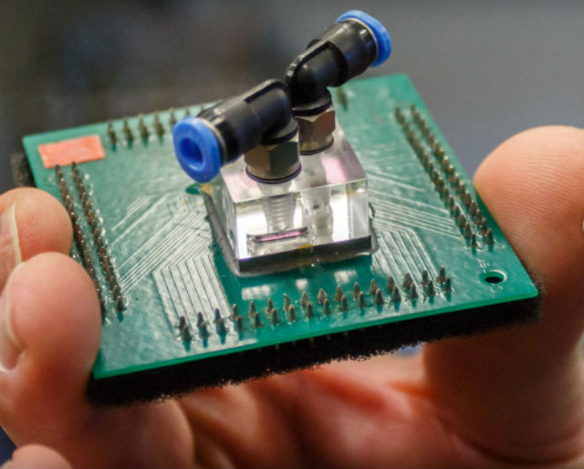 Инженеры IBM интегрировали в конструкцию систему жидкостного охлаждения: слои чипов чередуются с микроскопическими трубочками воды (фото IBM). 